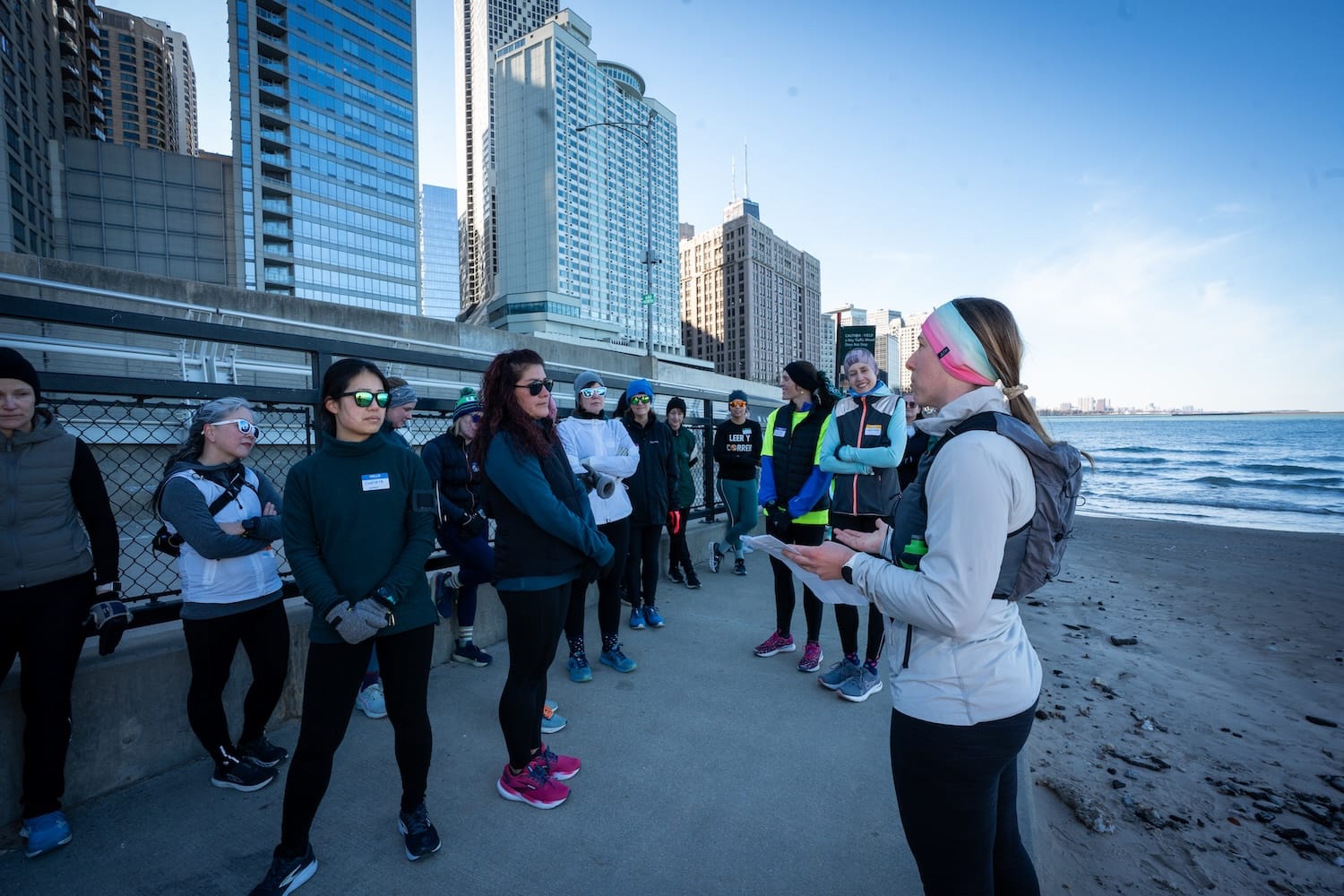 A person talking to a group of people outside in front of a downtown setting