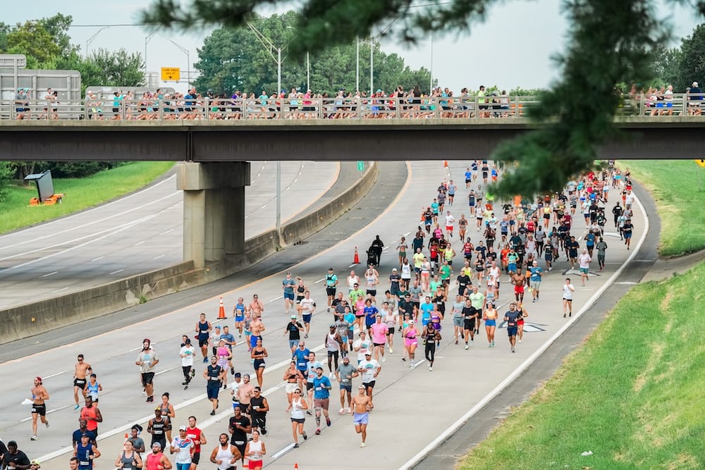 Runners running a race on a freeway with a bridge that goes over the freeway